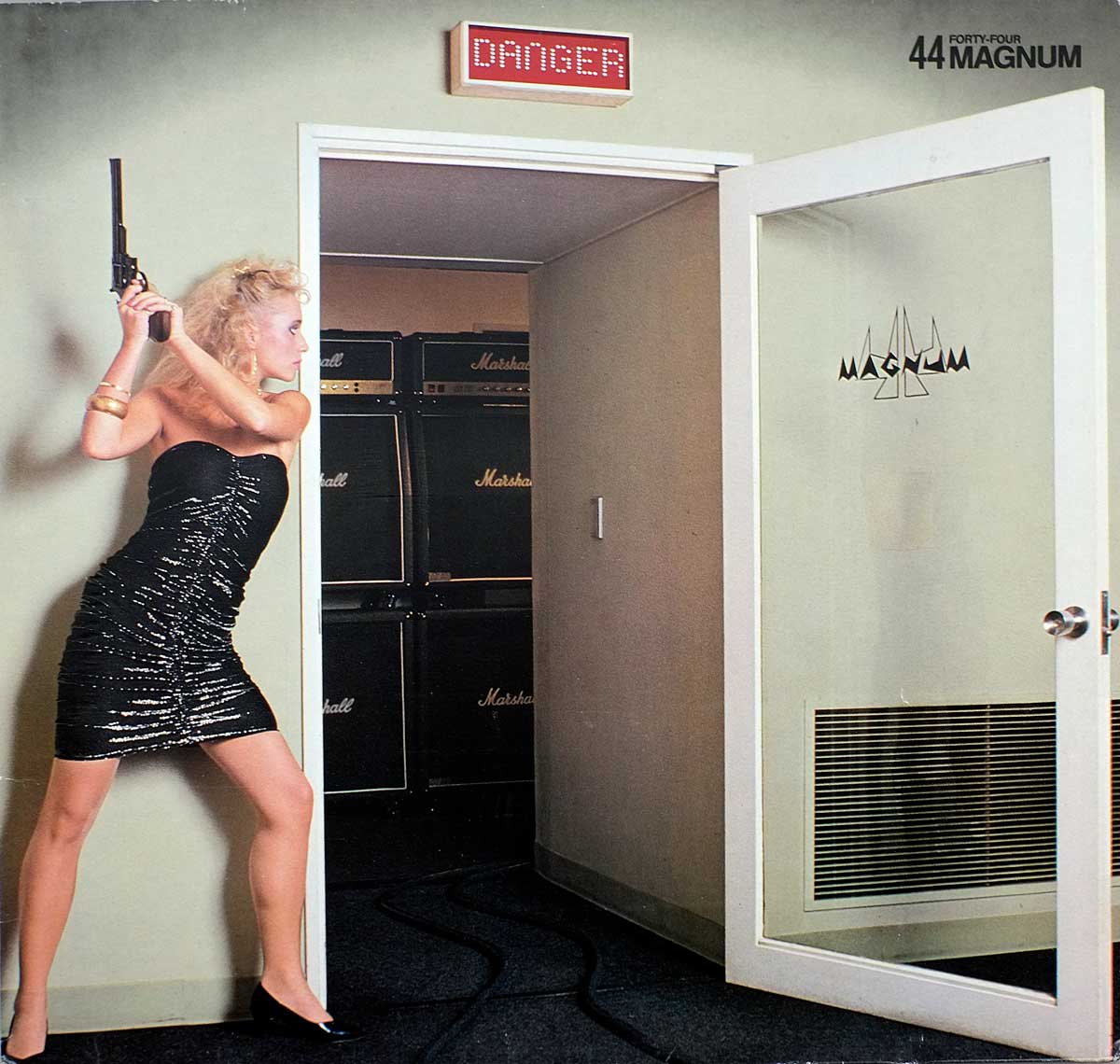 the album front cover shows a woman in a short black dress holding a gun in the air