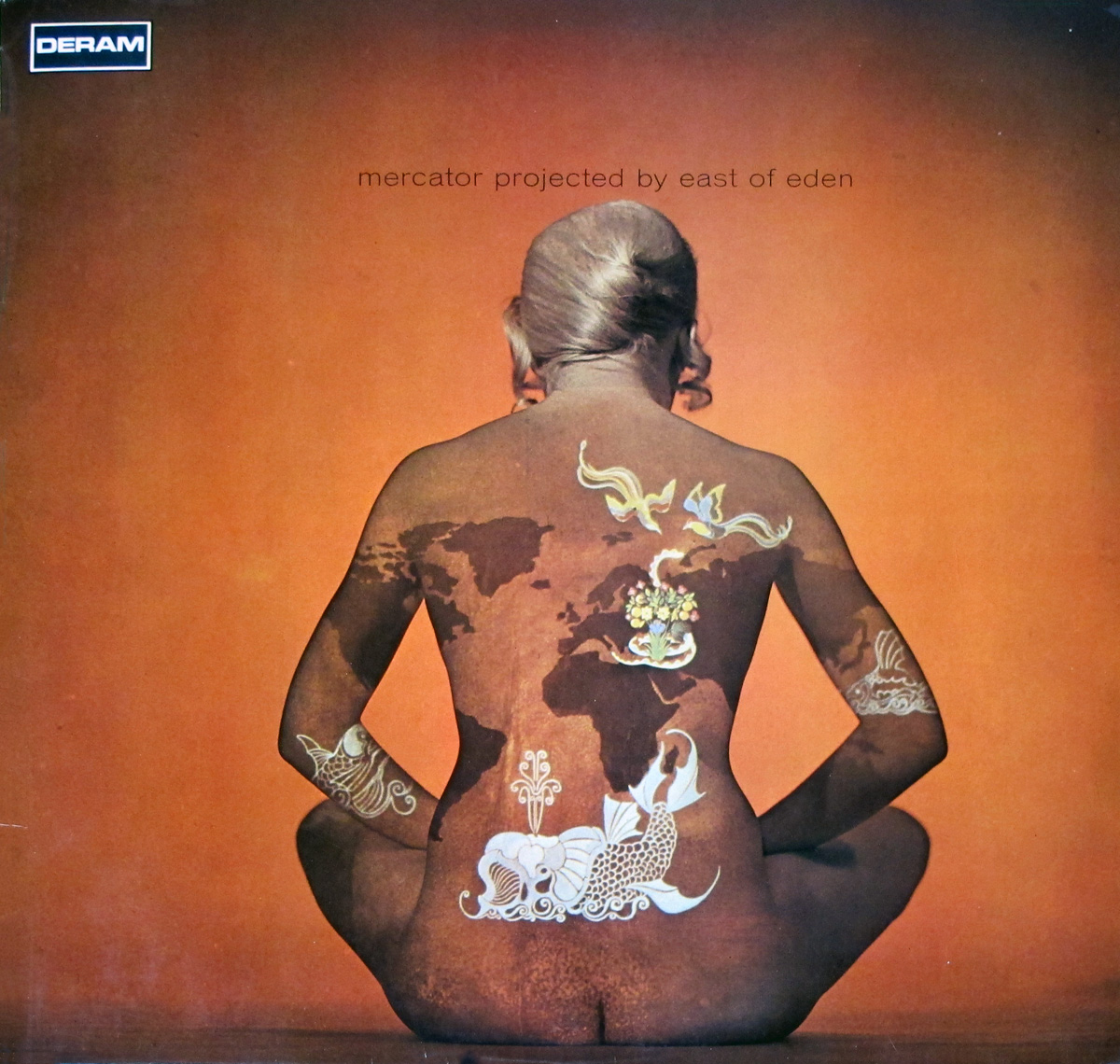 Album cover of Mercator Projected by East of Eden. The image shows a person seated cross-legged with their back facing the viewer, painted with a world map in Mercator projection. The map includes additional illustrations, such as birds, floral designs, and a koi fish. The background is a solid warm orange, and the album title, Mercator Projected by East of Eden, appears subtly at the top. Released by Deram Records in 1969 https://vinyl-records.nl/