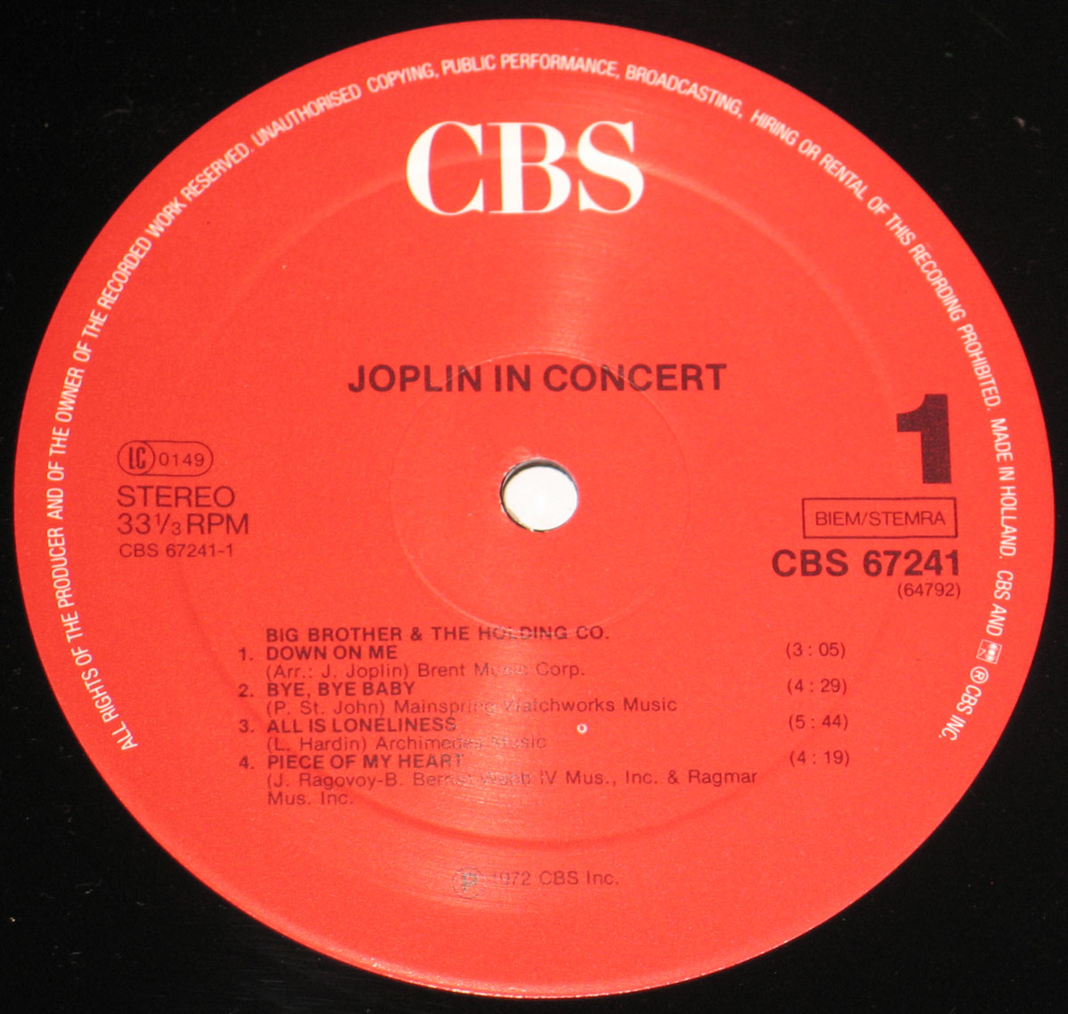 Close-up of CBS Red label for 'Joplin In Concert' Side One. The red label features the CBS logo in white at the top, with black text listing the album title, tracklist, and catalog number CBS 67241. Includes 'Down On Me,' 'Bye, Bye Baby,' 'All Is Loneliness,' and 'Piece of My Heart.' Pressed in Holland, 1972.