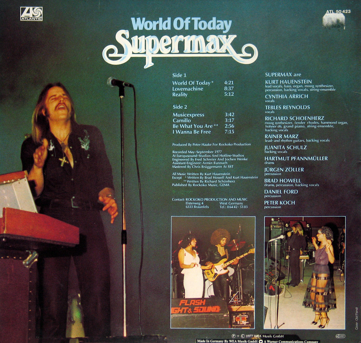 Back cover of SUPERMAX - World of Today (1977), featuring a dark-toned design with track listings, musician credits, and production details. On the left, Kurt Hauenstein is seen playing a keyboard, singing with eyes closed, dressed in a black shirt with a silver emblem. Below, two smaller concert photos show the band performing live. The 'Supermax' logo is displayed at the top, with the 'Atlantic Records' logo in the upper left corner.