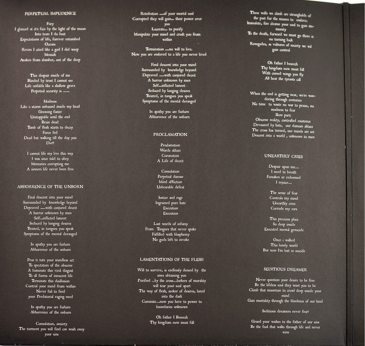 Inner sleeve of Entrapment's 'Lamentations Of The Flesh' LP showing printed lyrics to six songs in serif typeface on a dark background with no artwork or imagery.