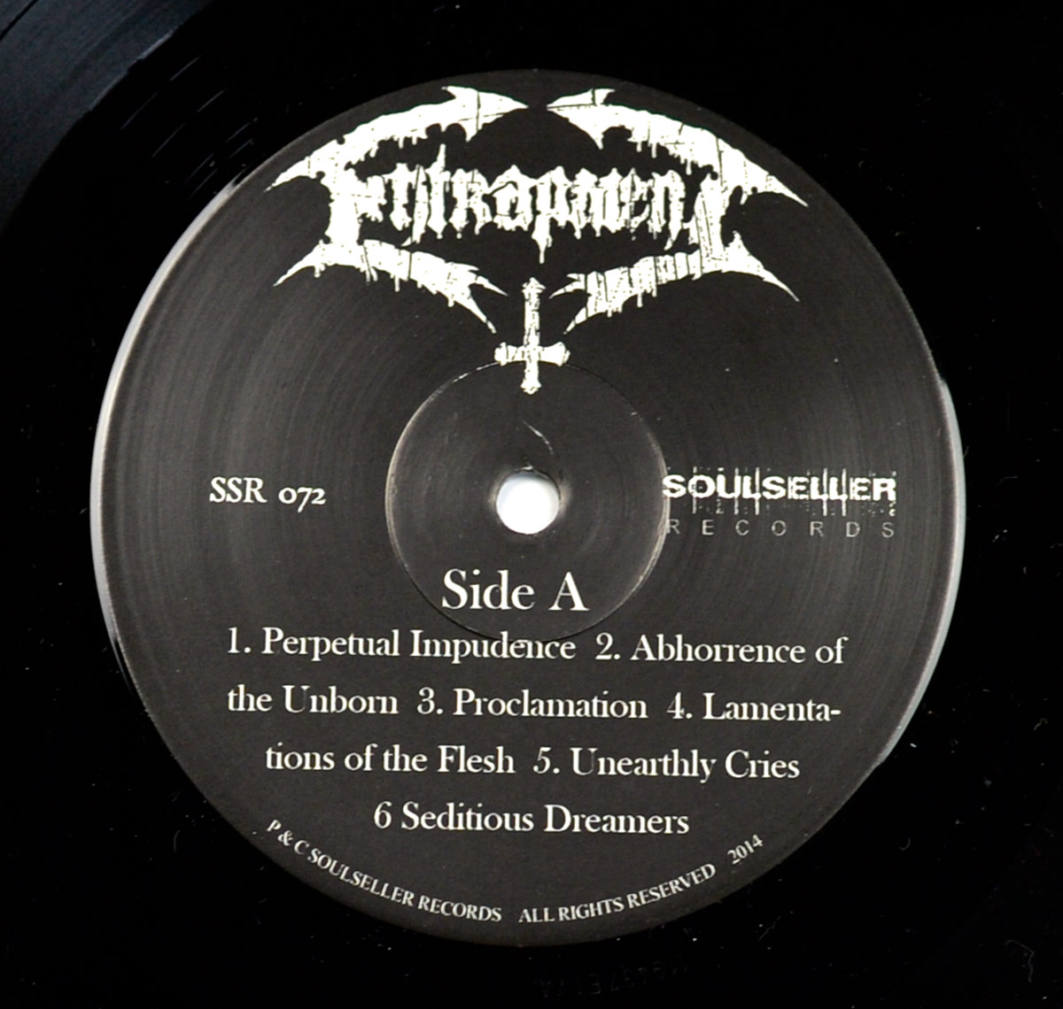 Label of Entrapment's 'Lamentations Of The Flesh' LP Side A with band logo, Soulseller Records, and tracklist printed in white on matte black vinyl center.