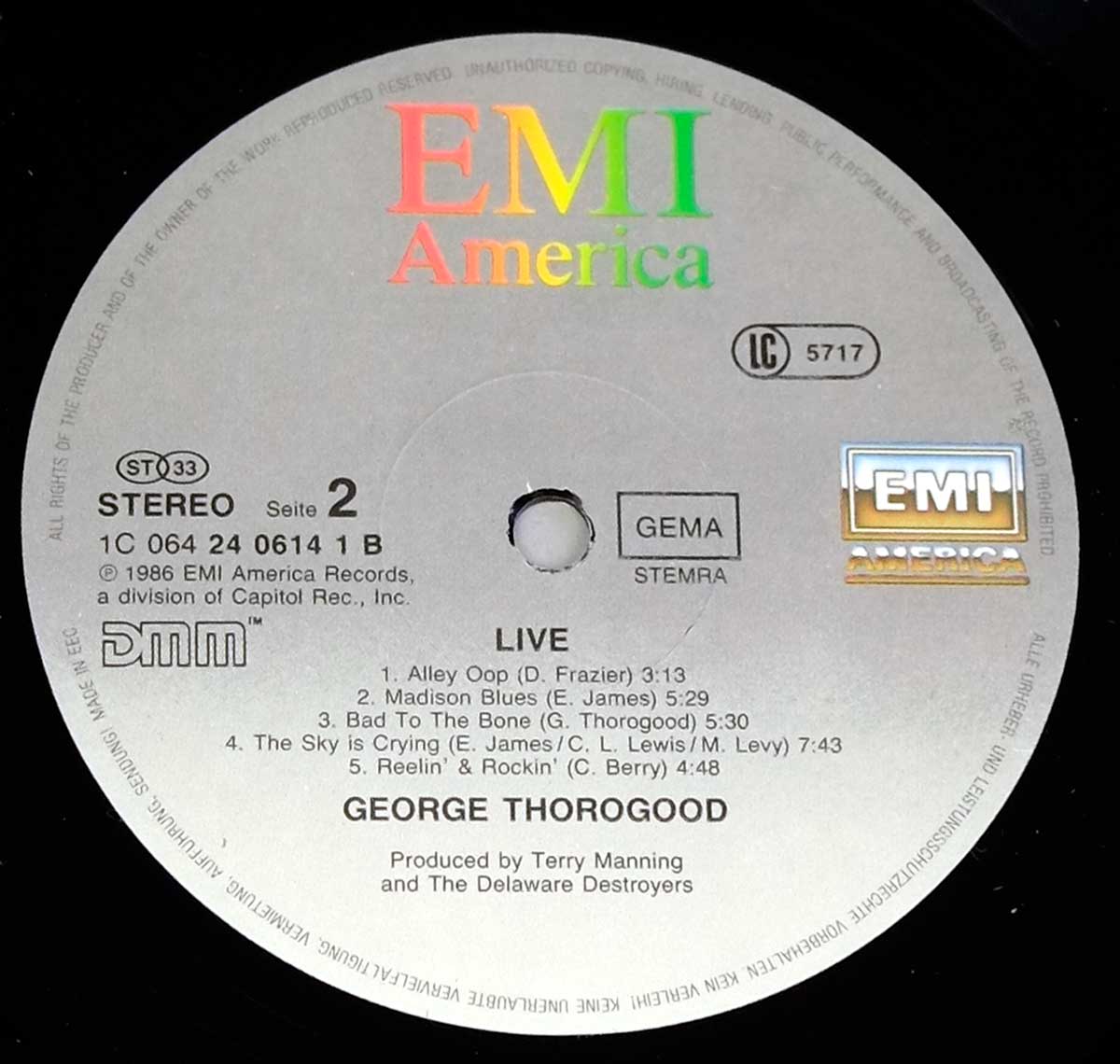 Side Two label of George Thorogood & The Destroyers – Live LP, silver EMI America label with DMM, GEMA, and catalog info, listing five songs including 'Bad to the Bone' and 'Reelin' & Rockin'' with colorful EMI logo and producer credits.