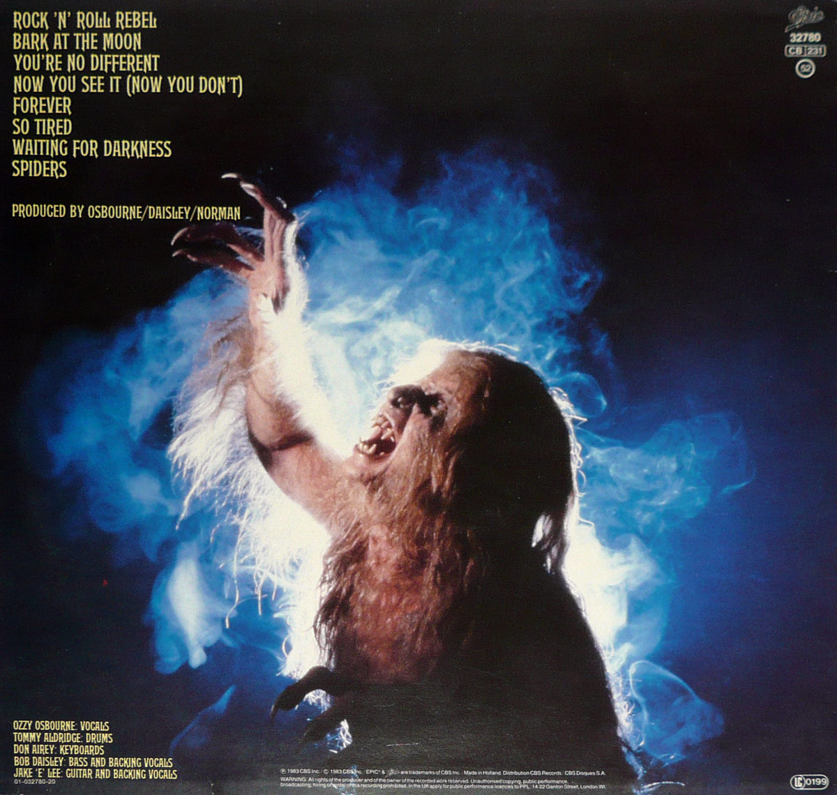Back cover of Ozzy Osbourne Bark at the Moon showing Ozzy as a werewolf-like creature reaching into a smoky blue void, with tracklist and credits in yellow text.