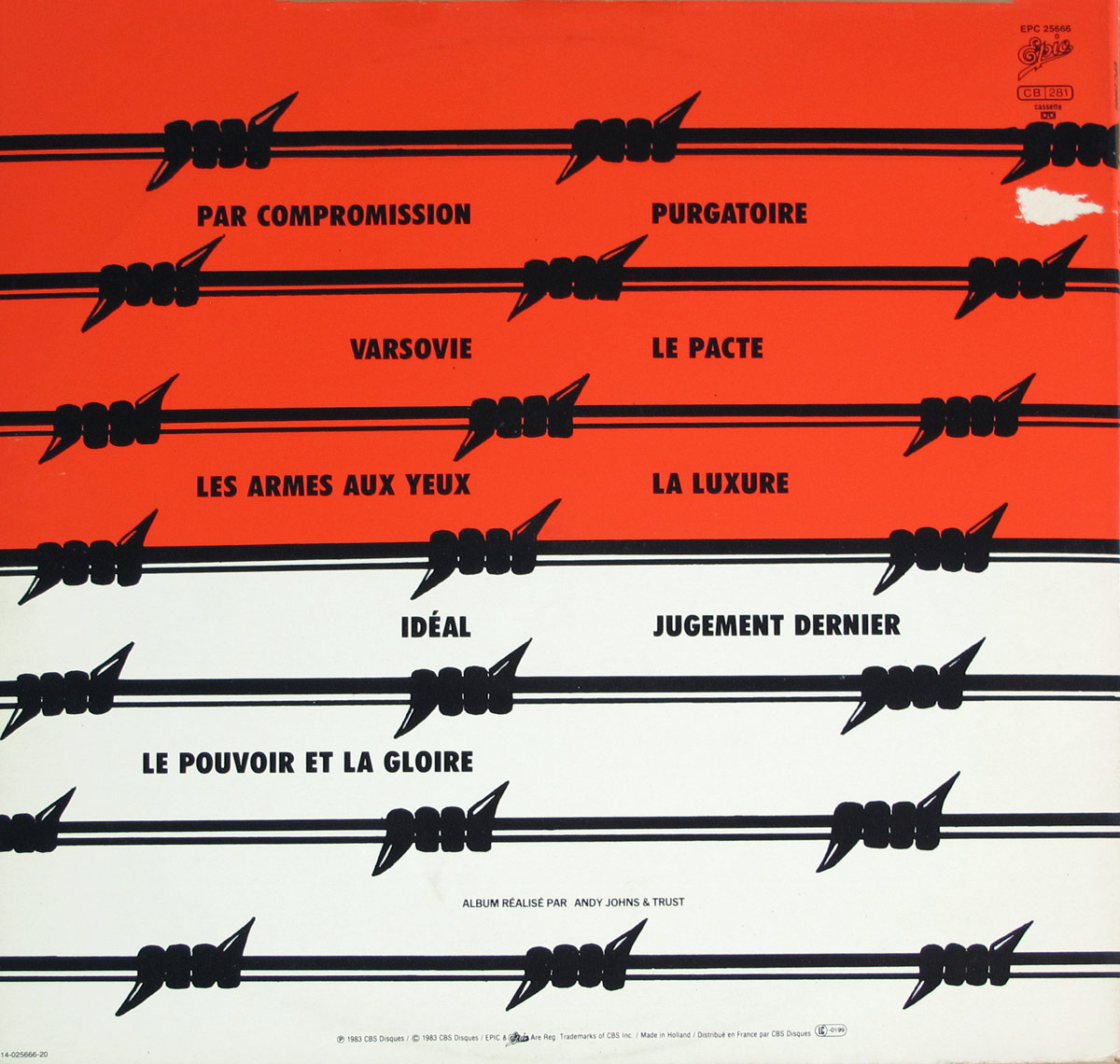 Back cover of TRUST’s 1983 album Idéal showing the full tracklisting printed over red and white bands, intersected by repeating black barbed wire graphics, with catalog and label details in the top right.