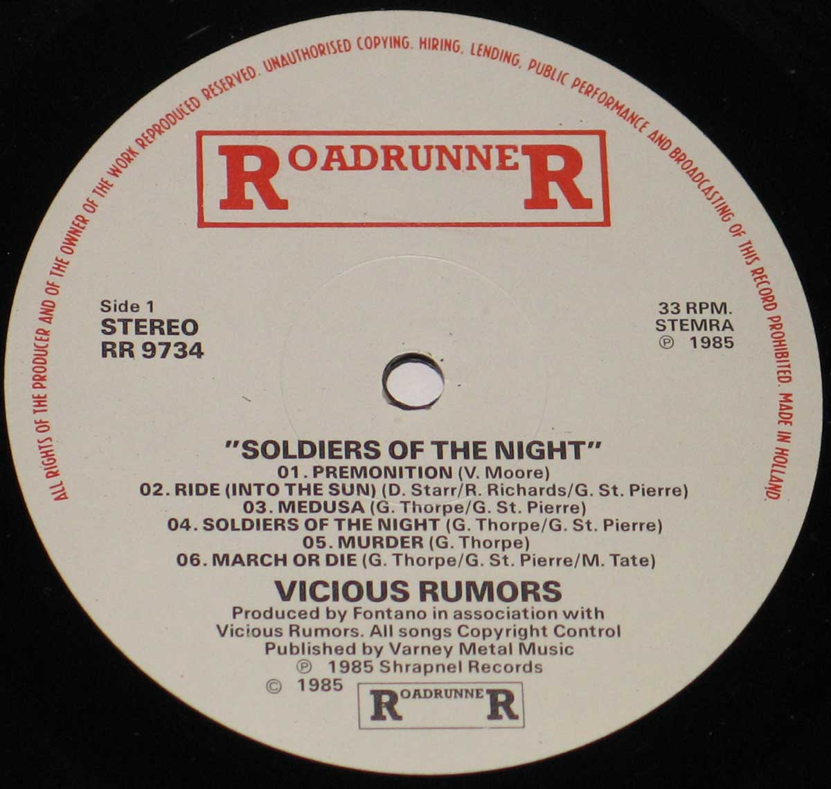 Close-up of the record label from Vicious Rumors – Soldiers of the Night (1985), released by Roadrunner Records (RR 9734). The cream-colored label features the bold red 'Roadrunner R' logo, tracklist for Side 1, and production credits. The record was made in Holland and plays at 33 RPM in stereo format. Shrapnel Records copyright details appear at the bottom.