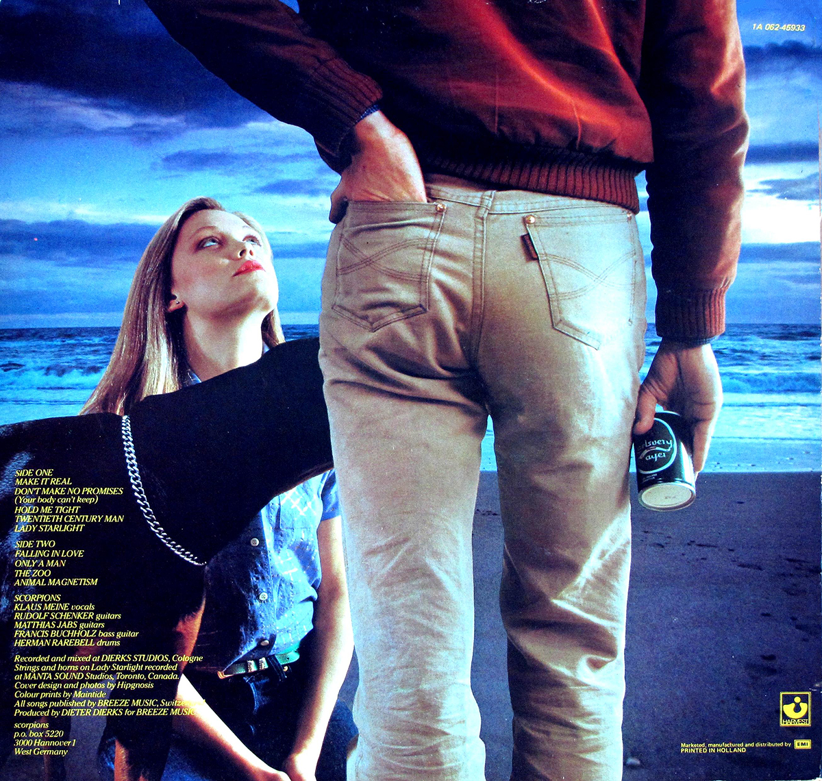 Back cover of Scorpions’ Animal Magnetism (1980) album. Features the same beach scene as the front cover, with a woman seated on the sand looking up at a man, now wearing a red jacket and holding a beer can. A Doberman dog stands beside her. The left side includes the tracklist for both album sides, along with recording credits and production details. Logos and publishing information are displayed at the botto