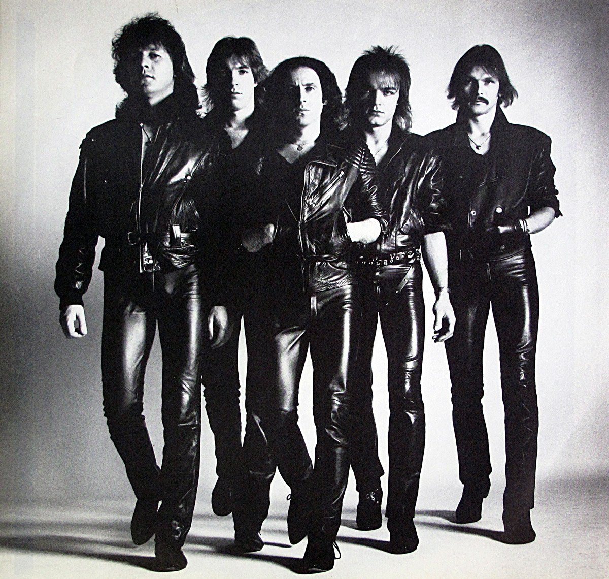 Scorpions band photo from the Love at First Sting French LP inner sleeve showing all five members in black leather outfits confidently walking toward the camera