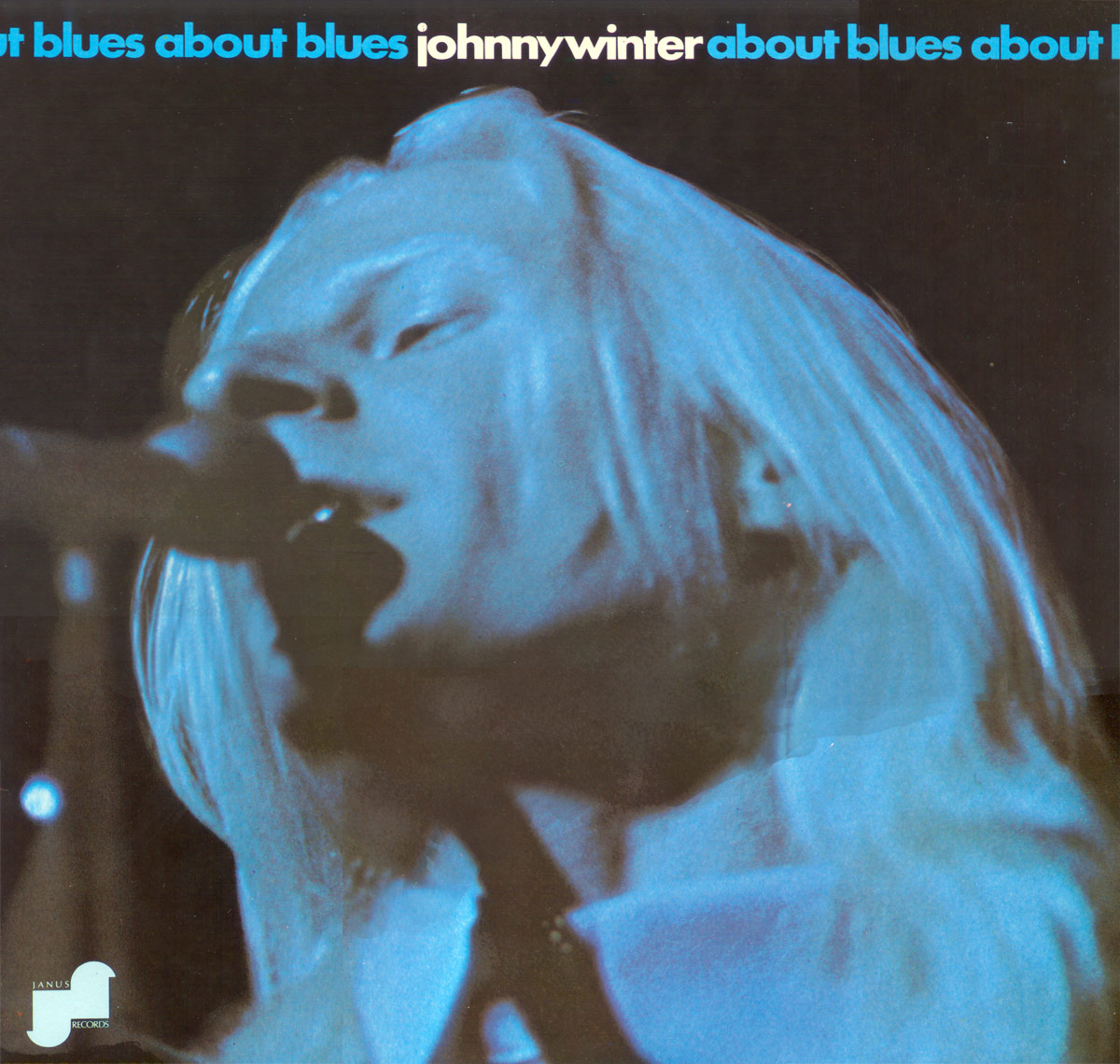 Album cover of About Blues by Johnny Winter. A close-up, high-contrast blue-tinted photograph of Johnny Winter singing into a microphone with his long white hair flowing. The album title, ‘about blues,’ repeats in blue and white text along the top, integrating with his name. The Janus Records logo appears in the bottom left corner https://vinyl-records.nl