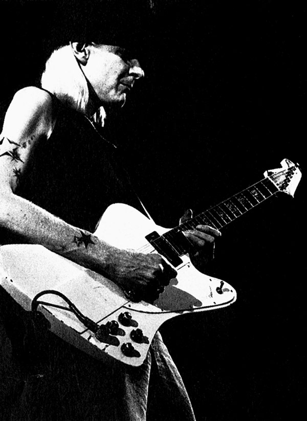 Photo of Johnny Winter playing a white Gibson Firebird on stage  - https://vinyl-records.nl/johnny-winter/biography/index.html