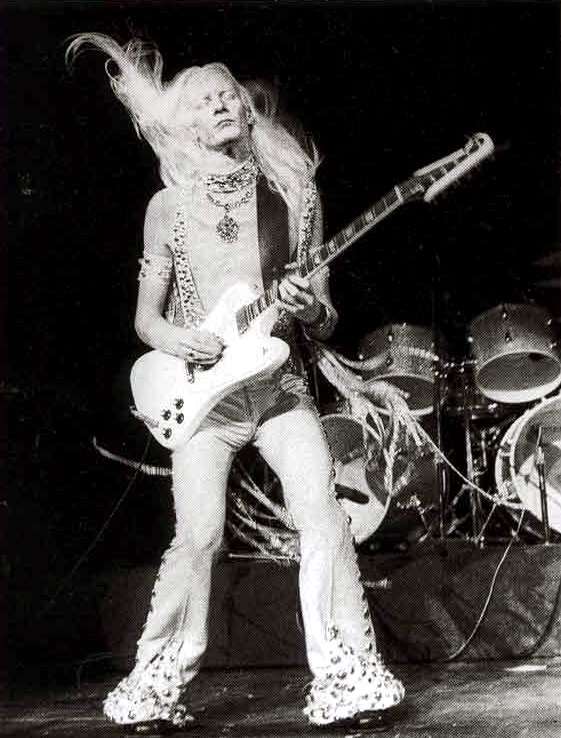 Photo of Johnny Winter playing a White Gibson Firebird at Madison Square Garden 