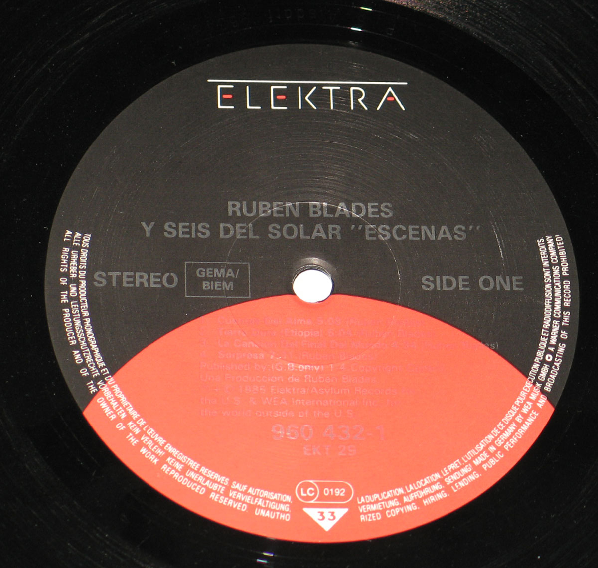 Close-up of Side One of the vinyl record for Rubén Blades' album 'Escenas.' The Elektra label is black with red and white text, featuring the album title, artist name, track details, and copyright information. The center hole is visible, surrounded by fine grooves reflecting light.