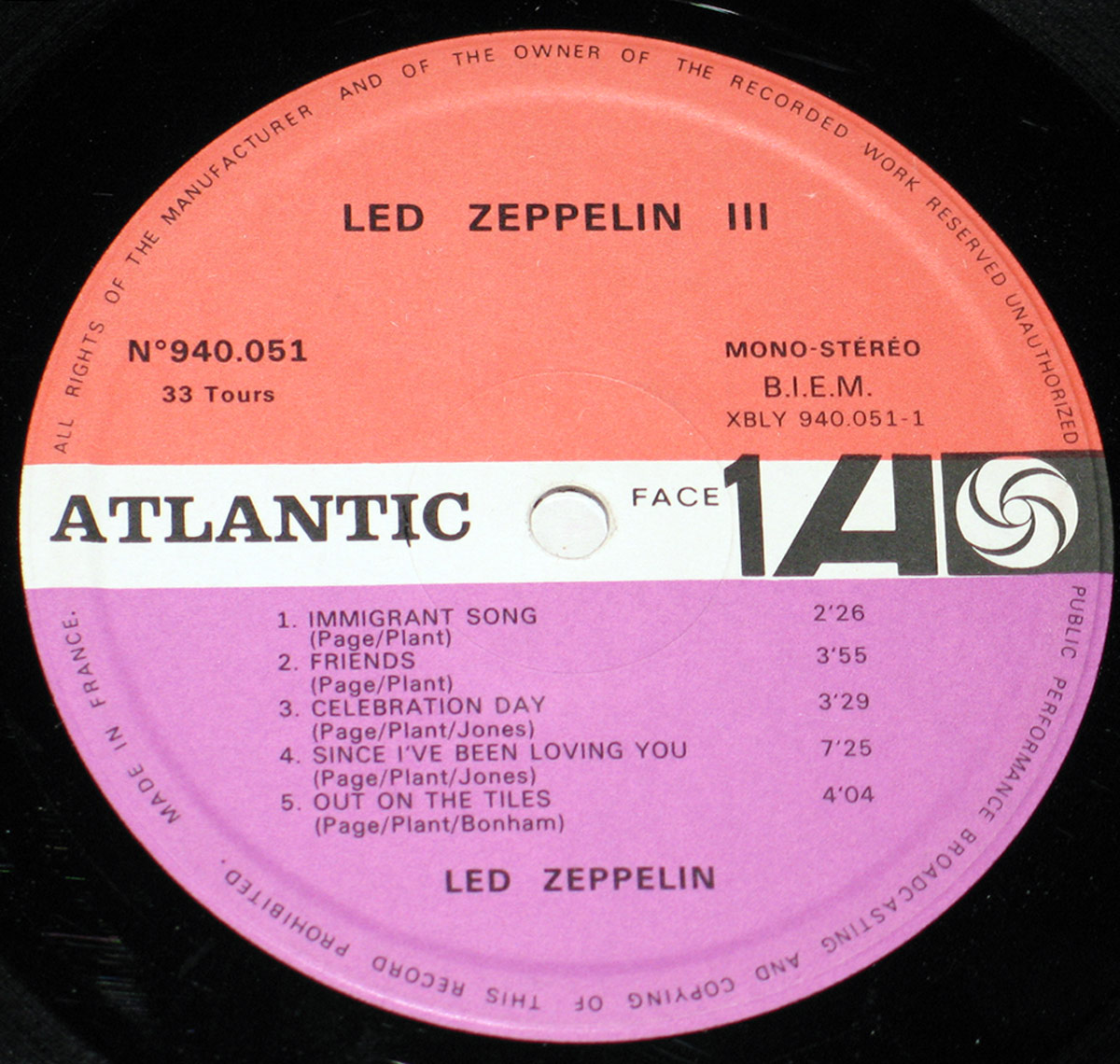 A close-up of the French pressing of Led Zeppelin III's vinyl label. The circular label is divided into red and purple sections, featuring the Atlantic Records logo, tracklist for Side One including 'Immigrant Song,' and details such as catalog number, mono-stereo designation, and copyright information.