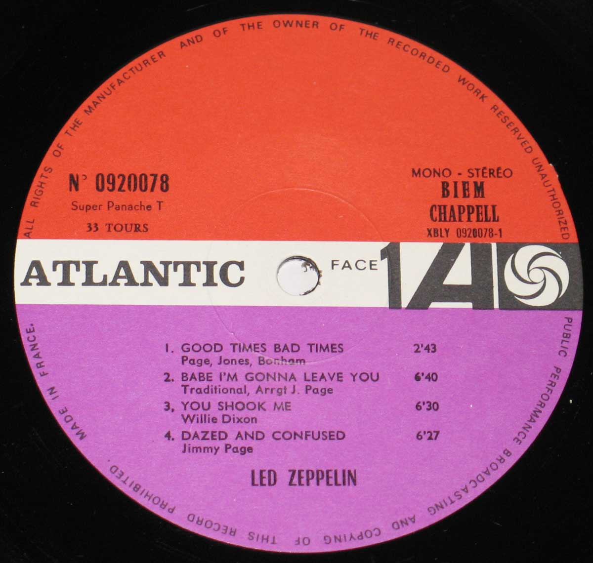 Close-up of Side One record label from the first French pressing of 'Led Zeppelin I', showing the distinctive red, white, and purple Atlantic Records label design. The top half is red with catalog number 0920078, 'Super Panache T', and 33 T Tours on the left, and mono-stereo indication, BIEM CHAPPELL rights society, and matrix XBLY 0920078-1 on the right. The white band in the middle contains the bold black ATLANTIC logo, 'Face 1', and the stylized Atlantic swirl logo. The bottom purple section lists the four tracks with songwriters and durations: Good Times Bad Times, Babe I'm Gonna Leave You, You Shook Me, and Dazed and Confused, credited to Page, Jones, Bonham, Willie Dixon, and Jimmy Page.