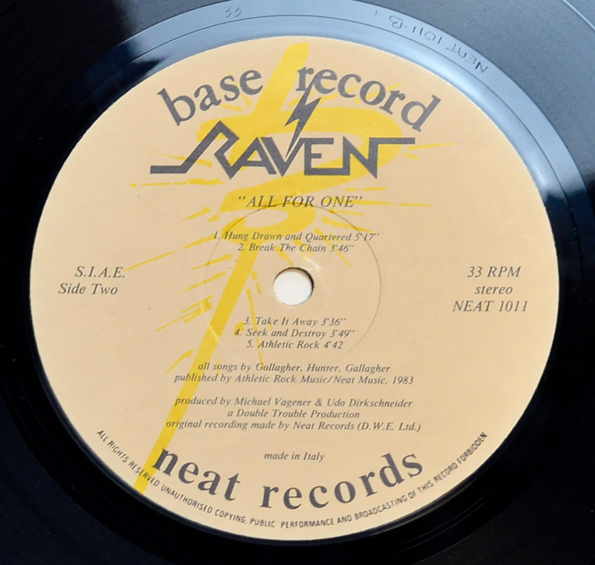 Raven 'All For One' Italy vinyl LP Side Two label with yellow lightning bolt graphic, black text listing five tracks, production credits, and label logos for base record and neat records.