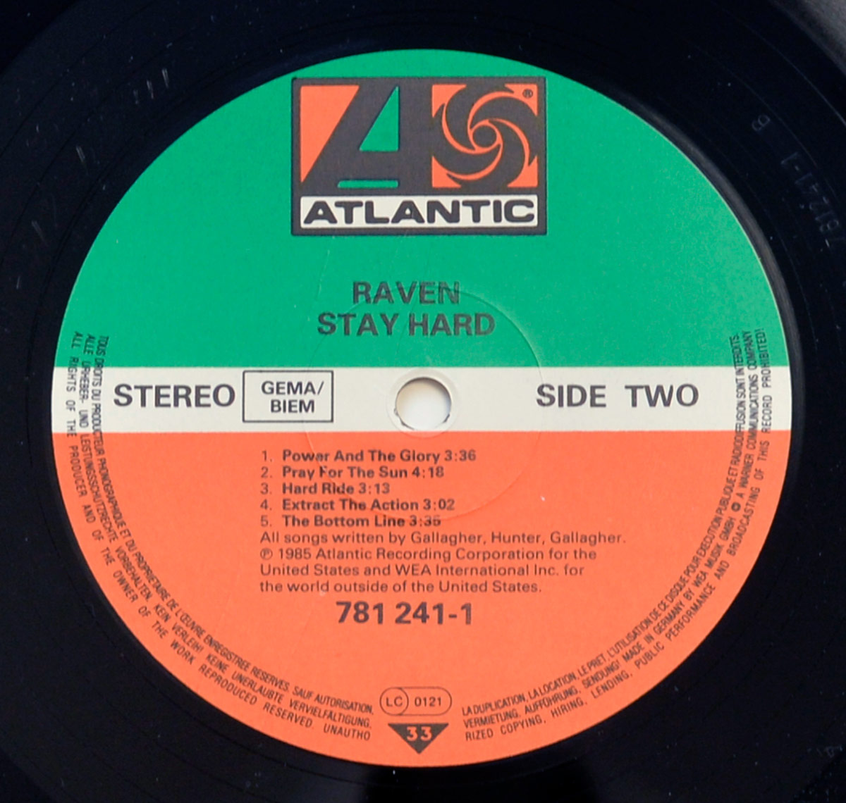 Close-up of Raven Stay Hard Side Two vinyl record label on Atlantic Records, with green, white, and orange label sections, Atlantic logo at top, Raven and Stay Hard printed above the spindle hole, stereo and GEMA/BIEM at left, Side Two at right, track titles and durations below, catalogue number 781 241-1, LC 0121, and 33 speed triangle near the bottom.