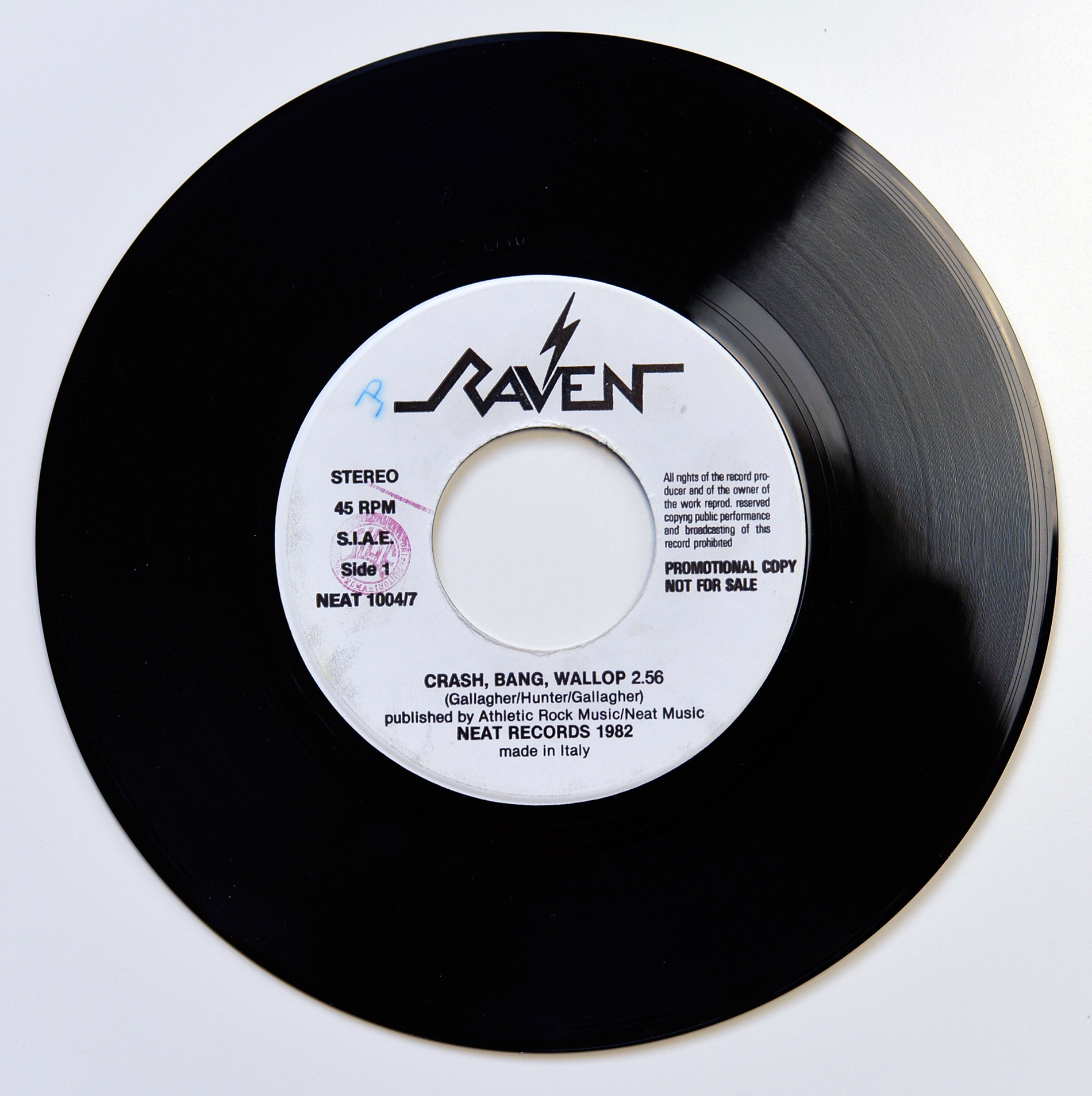 Raven Wiped Out bonus 7 inch black vinyl single photographed from above on a white background, with a white centre label showing the Raven logo at the top, STEREO 45 RPM SIAE Side 1 and NEAT 10047 on the left, promotional copy not for sale text on the right, and Crash, Bang, Wallop listed at the bottom.