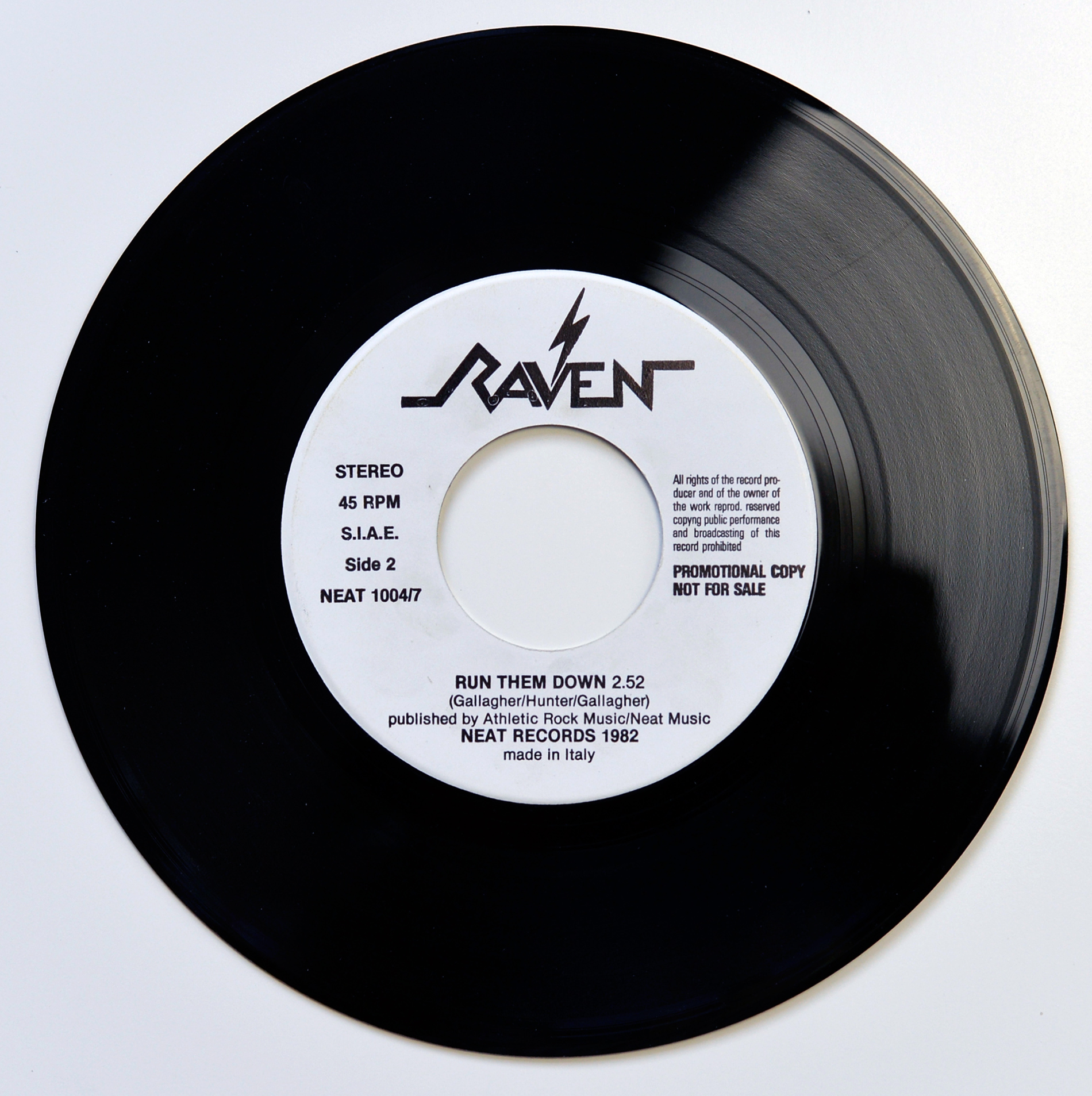 Raven Wiped Out bonus 7 inch black vinyl single photographed from above on a white background, with a white centre label showing the Raven logo at the top, STEREO 45 RPM S.I.A.E. Side 2 and NEAT 10047 on the left, promotional copy not for sale text on the right, and Run Them Down listed at the bottom.