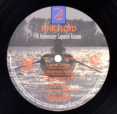 Germany label: Pink Floyd – A Momentary Lapse of Reason – boat-rower background, EMI logo at left; SIDE 1; GEMA/BIEM printed to the right of spindle; catalogue number in 064‑… style on right; orange track text.