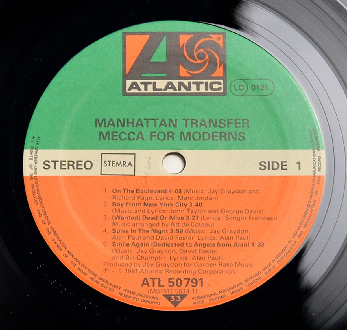 Close-up of Side One label from THE MANHATTAN TRANSFER - Mecca For Moderns vinyl LP. Features green, white, and orange Atlantic label design with track titles, credits, and catalog number ATL 50791.