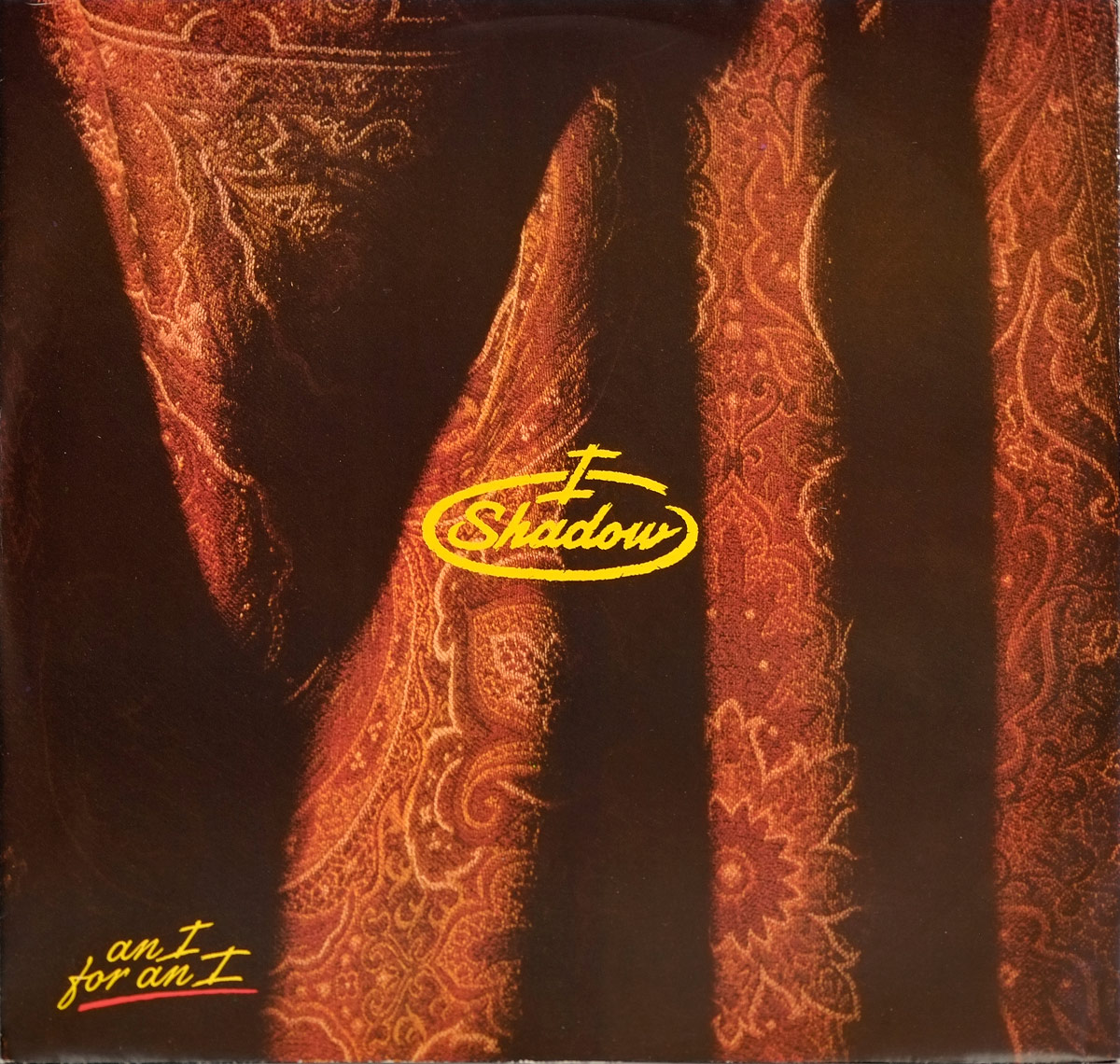 Custom inner sleeve of I SHADOW – An I For An I with intricate red and gold paisley fabric pattern and yellow band logo and title.