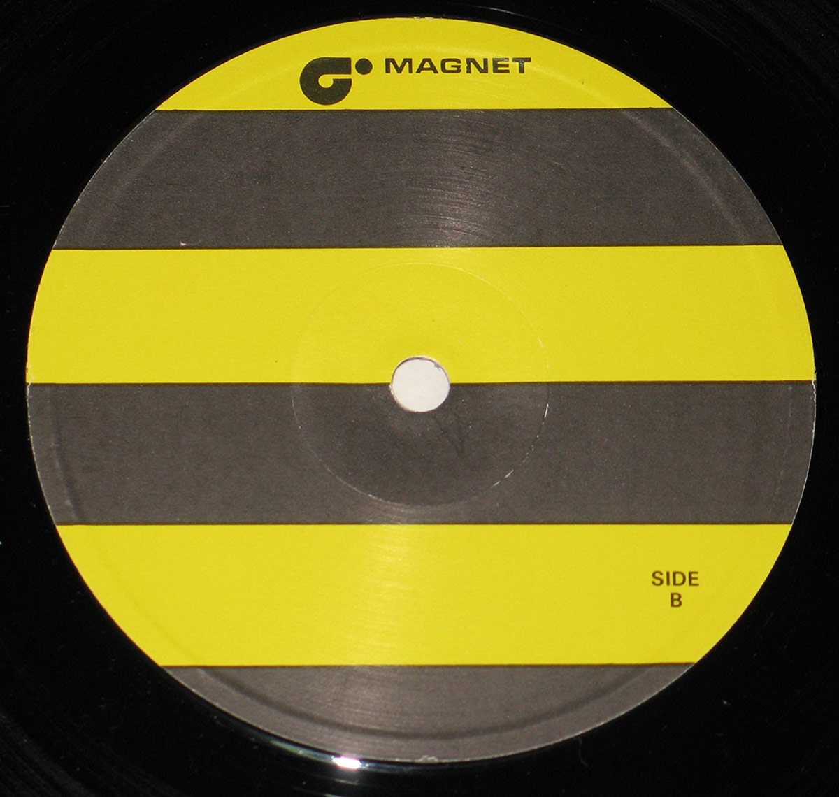 Side B label of Bad Manners' Ska 'n' B LP on Magnet Records, featuring a bold design of alternating yellow and black horizontal stripes. The Magnet Records logo is printed at the top in black text, with the words 'SIDE B' appearing in small black font at the bottom right. No track information or artist details are shown on this label side.