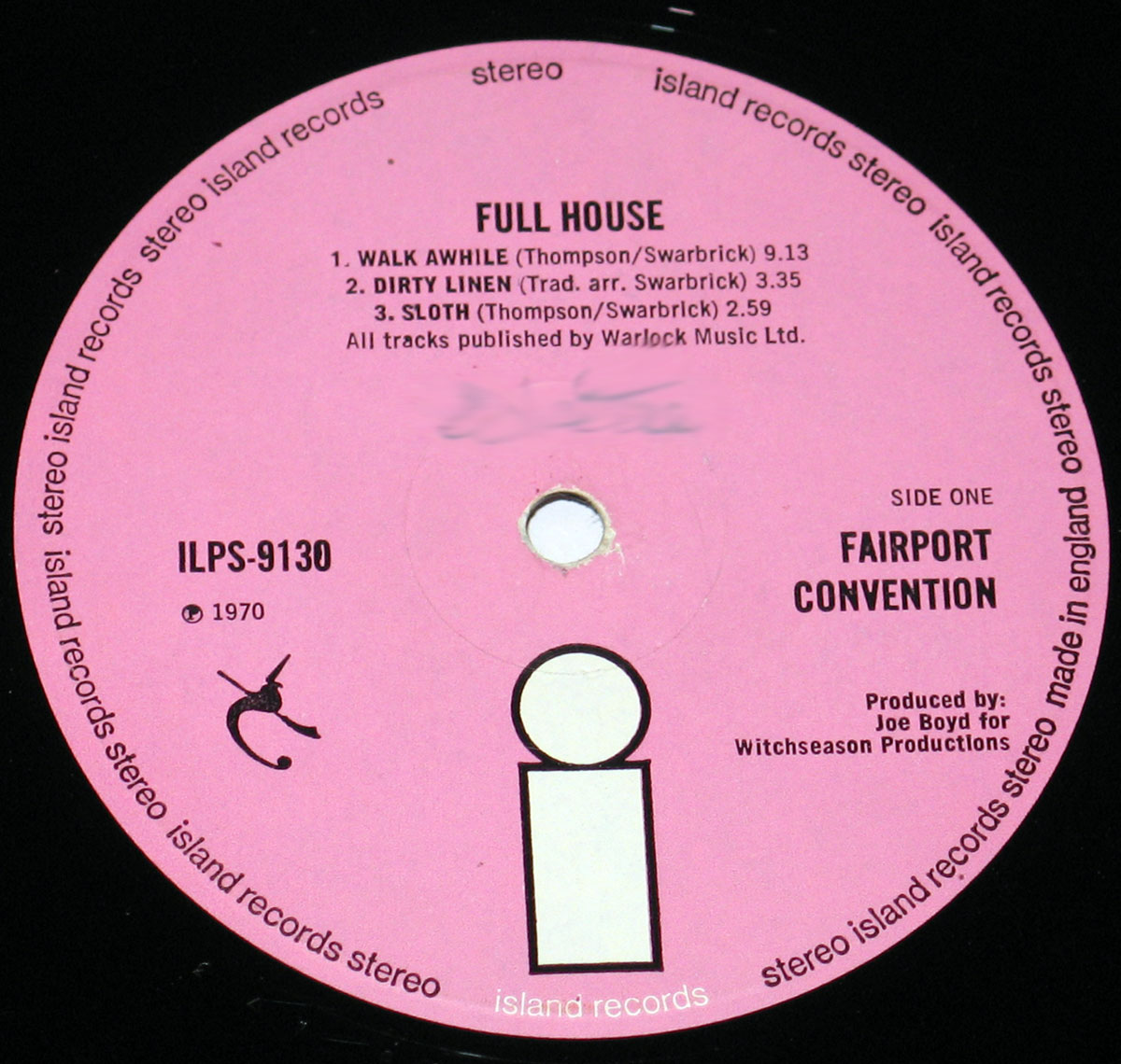 High resolution close-up of the Side One record label from Fairport Convention's 1970 album Full House, pressed by Island Records. The label is a solid pink background with black text. Around the outer edge, the words 'island records stereo made in england' repeat in a circular band. At the top, the album title 'FULL HOUSE' is printed in bold, followed by the tracklist: 1. Walk Awhile (Thompson/Swarbrick) 9:13, 2. Dirty Linen (Trad. arr. Swarbrick) 3:35, 3. Sloth (Thompson/Swarbrick) 2:59. On the right side appears 'SIDE ONE' and the band name 'FAIRPORT CONVENTION'. Below, it states 'Produced by Joe Boyd for Witchseason Productions'. The Island Records logo — a minimalist lowercase 'i' in a box — is placed prominently at the bottom.