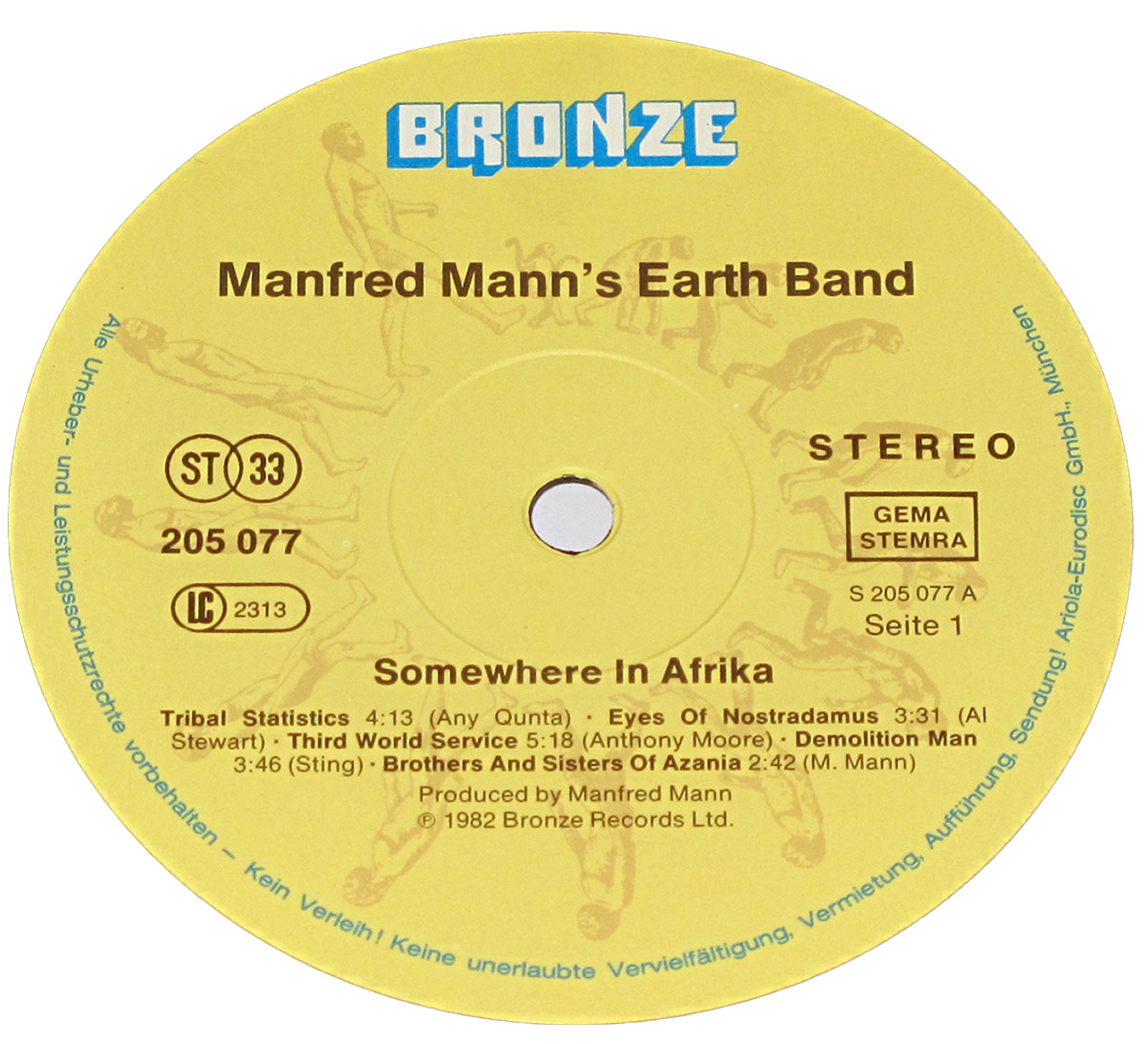 Close-up of the Side 1 record label of Manfred Mann’s Earth Band 'Somewhere in Afrika'. The label is printed on a warm yellow background featuring the trademark Bronze Records design: a circular ring of stylized running man silhouettes moving clockwise around the perimeter. The Bronze logo appears at the top in bold blue lettering with a subtle 3D effect. Centered beneath it is the band name, with track titles for Side 1—Tribal Statistics, Eyes of Nostradamus, Third World Service, Demolition Man, and Brothers and Sisters of Azania—printed in dark brown text. Technical markings such as 'ST 33', catalog number 205 077, LC 2313, and 'GEMA STEMRA' appear on the left and right. The text 'Seite 1' and the matrix number S 205 077 A identify this as the German pressing. The spindle hole sits in the middle of a faintly embossed circular guide. The yellow tone, classic Bronze artwork, and clean typography give the label a distinct early-80s aesthetic.
