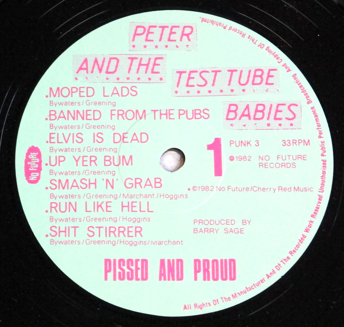Close-up of Side One record label for the 1982 punk album 'Pissed and Proud' by Peter and the Test Tube Babies. The label features a mint-green background with bold pink text and graphics. The band name is split across the top into two pink banner-style blocks reading 'Peter and the' and 'Test Tube Babies' in uppercase. The tracklist for Side One is printed in pink, with each song title followed by songwriting credits in smaller text. A bold number '1' indicates the side, along with catalog number 'PUNK 3', 33 RPM speed, and the No Future Records logo vertically on the left. The lower section features the album title 'Pissed and Proud' in large capitals, along with copyright and production credits.