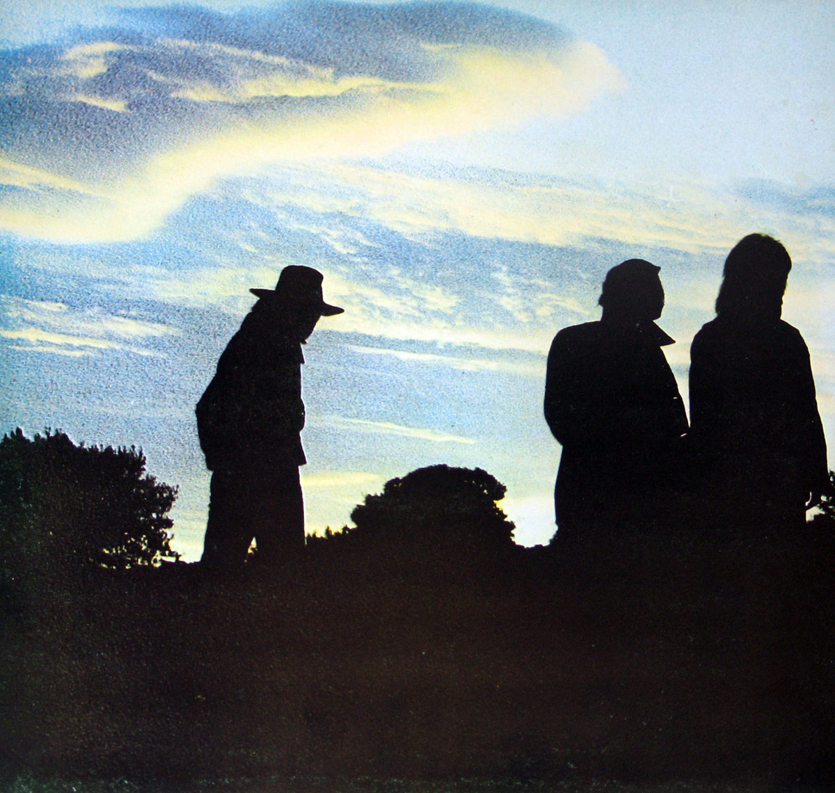 Inner cover of 'Power' by Barrabás (1972), featuring three silhouetted figures against a vast dusk sky with soft clouds and a faint horizon glow. The leftmost figure wears a wide-brimmed hat, while the others stand closer together, creating a contemplative and atmospheric scene.