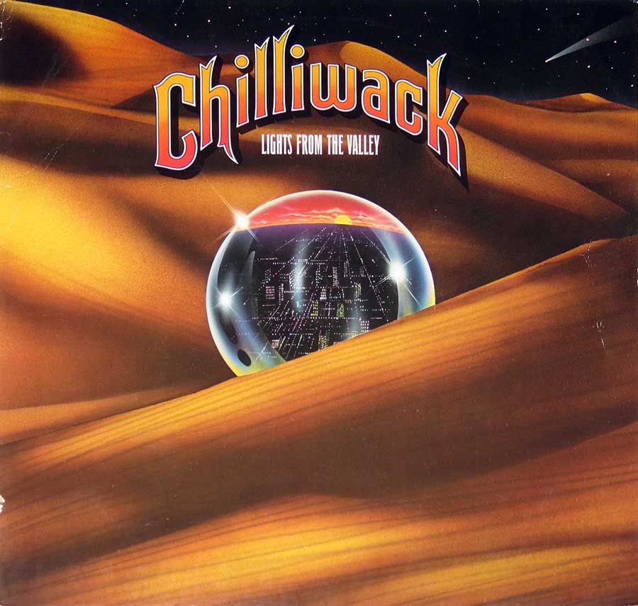 Album cover for Chilliwack's 'Lights from the Valley.' The cover features a surreal desert landscape with sand dunes under a dark cosmic sky. A crystal-like sphere sits on the dunes, encapsulating a glowing cityscape. The band's name, Chilliwack, appears at the top in bold stylized font, with the album title 'Lights from the Valley' below. https://vinyl-records.nl