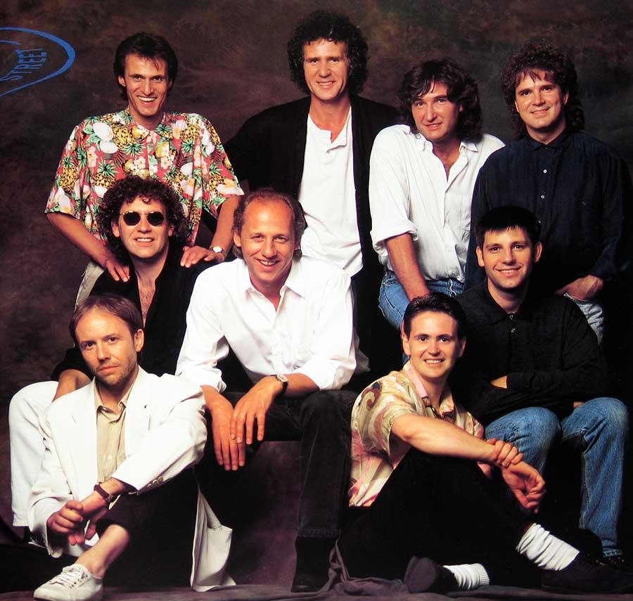Large full page group photo of the Dire Straits band and the production team 