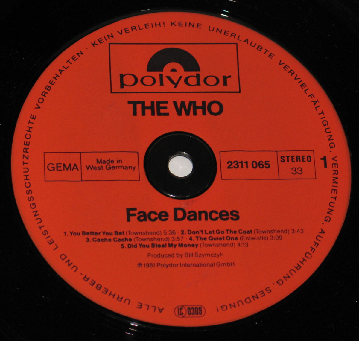 Record label of The Who’s Face Dances album, pressed in West Germany by Polydor, featuring a red background with black text, the Polydor logo, catalog number 2311 065, and production credit to Bill Szymczyk.