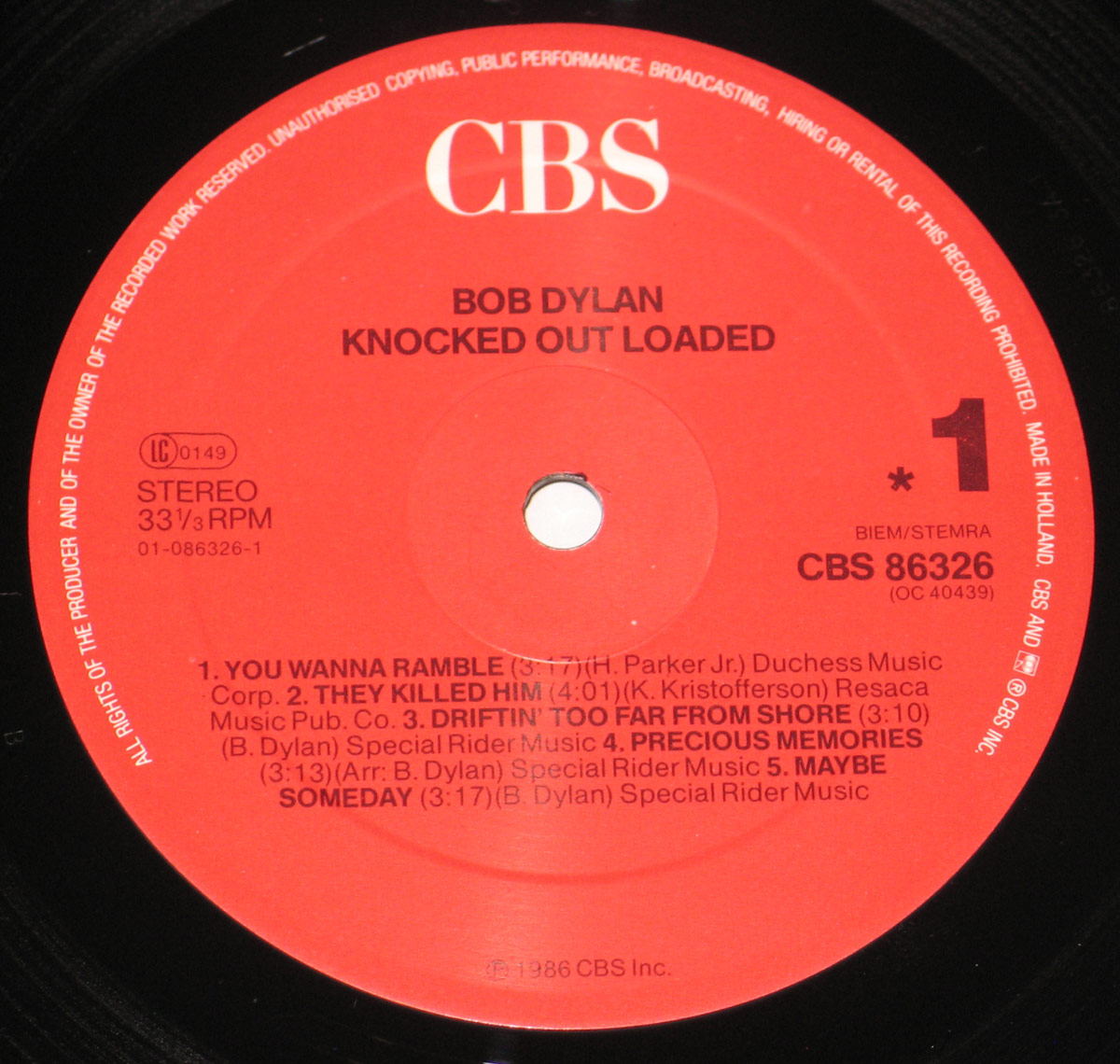 Side One label of Bob Dylan’s Knocked Out Loaded LP with red CBS 86326 label, song titles and publishing details in black text, pressed in Holland, 1986.