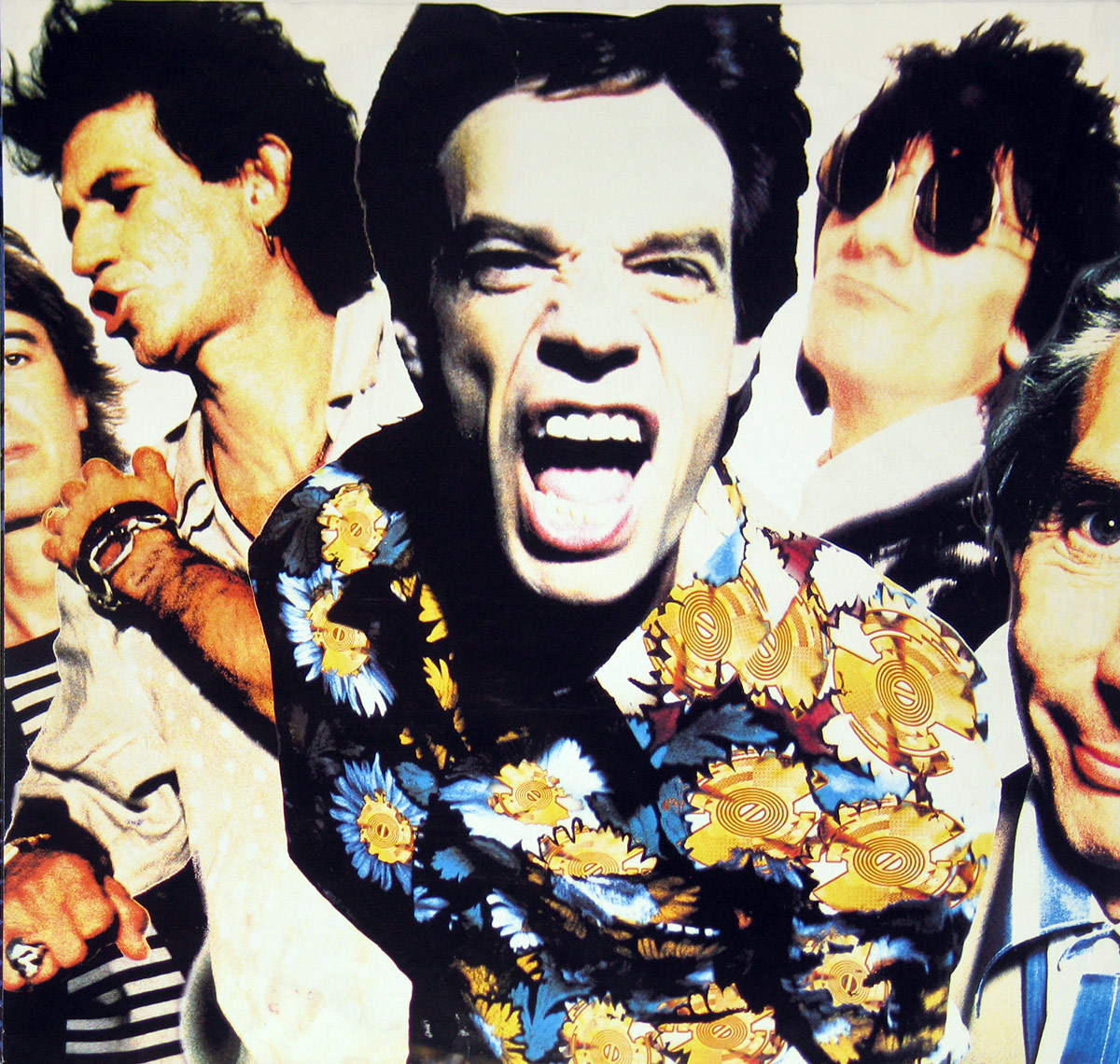 Custom inner sleeve photo of the Rolling Stones Steel Wheels album. The image shows a vivid collage-style portrait of the band members. Mick Jagger dominates the center, leaning forward with mouth wide open in a raw scream, wearing a floral shirt covered with stylized orange and yellow circular gear-like patterns. To his left Keith Richards appears mid-gesture, while Ronnie Wood smiles in dark sunglasses, and other members are partly visible in cropped sections, their faces and bodies overlapping. The composition is bright, chaotic, and full of energy, capturing the personality and flamboyance of the Stones.