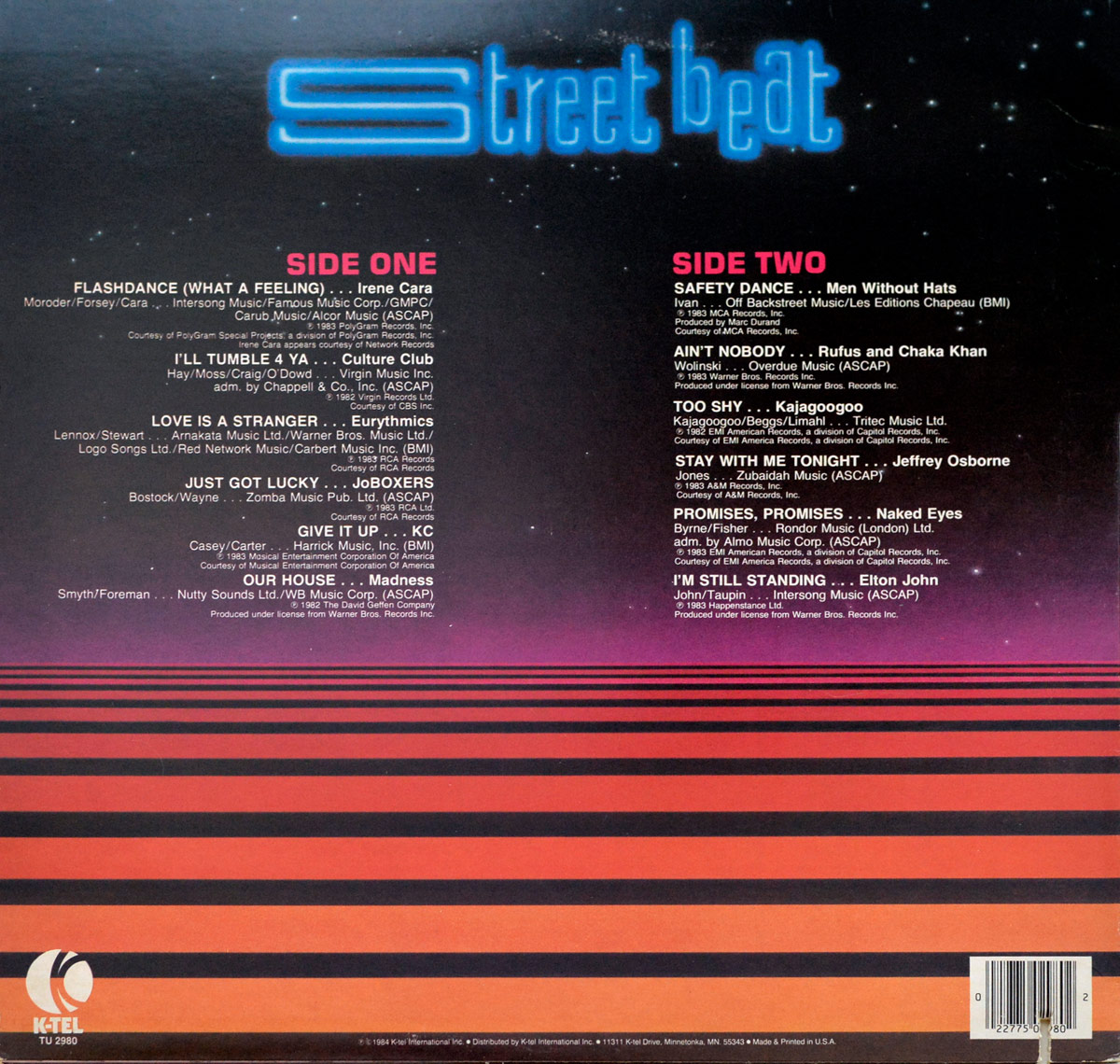 Back cover of the 1984 K-Tel compilation album Street Beat: New Music Hot Sounds. The design continues the futuristic neon theme with a gradient of deep purple fading into vivid red and black horizontal stripes across the bottom half. At the top, the Street Beat title glows in electric-blue neon letters. On the left, Side One tracks are listed in white text with red SIDE ONE heading, featuring Irene Cara, Culture Club, Eurythmics, JoBoxers, KC, and Madness. On the right, Side Two tracks are listed under a red SIDE TWO heading, featuring Men Without Hats, Rufus & Chaka Khan, Kajagoogoo, Jeffrey Osborne, Naked Eyes, and Elton John. Publishing and rights information appears beneath each track. At the lower left corner, the white K-Tel logo and catalog number TU 2980 are shown, with distribution details. A barcode is displayed on the lower right corner.